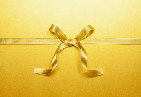 golden ribbon tied in a bowの写真素材