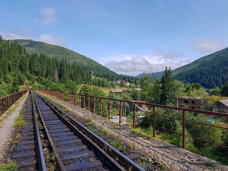 Beautiful mountain narrow-gauge railway road, rails in the mountains of the Carpathians passing through the forest in the village of Vorohta, Ivano-Frankivsk region, Ukraineの写真素材