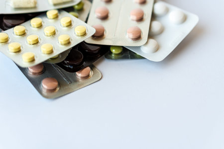 Medicine and pills. Multi-colored medicines on a white background close-up. Plate with multi-colored...