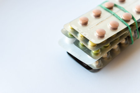 Medicine and pills. Multi-colored medicines on a white background close-up. A pack of plates with...