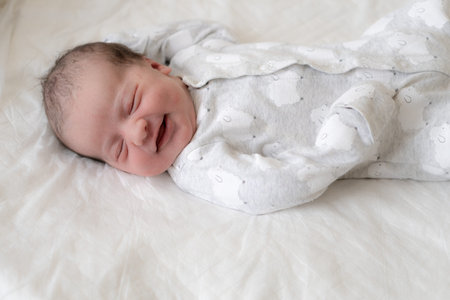 Portrait of a newborn baby in the first minutes of life, who smiles through a dream. Newborn baby...