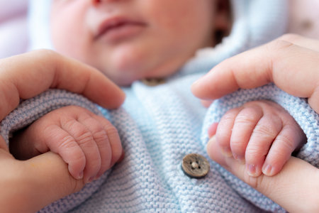 Hands of a newborn and his mother together. Close-up mom holds the hands of a newborn. Newborn baby...