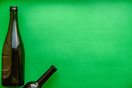 garbage, ecology, garbage sorting concept - layout of two glass wine bottles on a green background copy spaceの写真素材