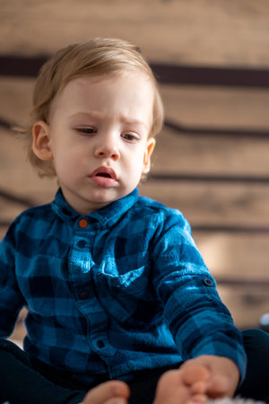 childhood, infant, minor concepts - close up one blonde black-eyed sad, offended child baby boy on...