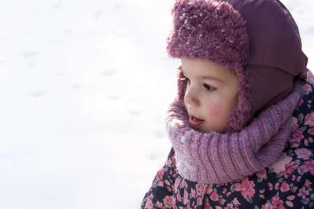 Winter, family, childhood concepts - close-up portrait authentic little preschool minor baby girl in pink warm clothes walking in snowy frosty weather day. happy pretty cute kid face have fun outdoorsの写真素材