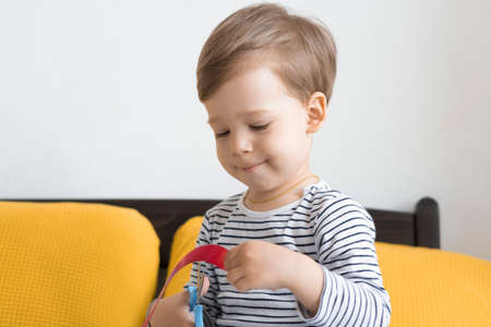 Two preshool, toddler children read large interesting book of fairy tales on yellow bed. Siblings little twins reader have fun, happy kid on quarantine at home. Friendship, family, education conceptの写真素材