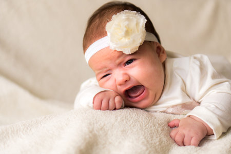 Childhood, motherhood, emotions, fashion concept - worried sad crying chubby baby with open mouth...