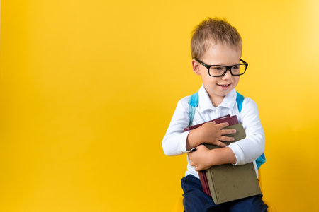 Banner Funny Cute Preschool Child Boy 3-4 years in Glasses hug Book Has Good Idea on Yellow Background Copy Space. Happy Kid Go Back to School, Kindergarten. Success, Winner, Genius, Superhero conceptの写真素材