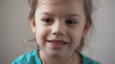 Portrait Funny Happy little kid close up happy preschool girl smiling child looking at camera pretty natural face. sincere emotions ashamed, embarrassed clean skin dermatology, pediatric dentistryの写真素材