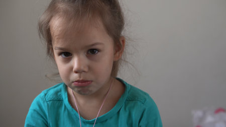 Portrait little girl sad upset child burst into tears cries sob looking at camera indoors. sincere children emotions feelings at home crying kid with pretty face. Concept childhood insult offend griefの写真素材