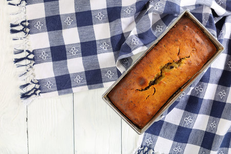 freshly baked delicious banana bread with walnuts and chocolate pieces in a loaf pan with kitchen...