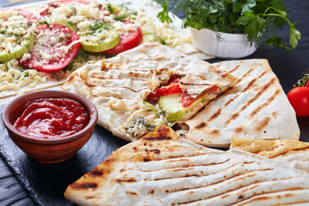 grilled flatbread stuffed with tomato and zucchini slices, greens and grated mozzarella cheese -...