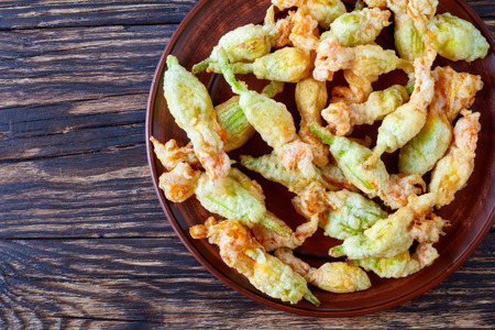 fresh zucchini flowers was stuffed with ricotta, parmesan, anchovies and deep fried in tempura batter, italian cuisine, horizontal view from above, close-up, flat layの写真素材