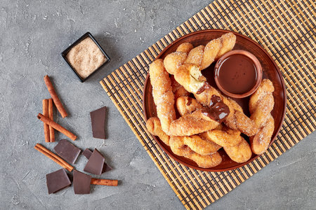 Twisted Korean doughnuts - Kkwabaegi sprinkled with sugar and served with chocolate sauce on a clay...