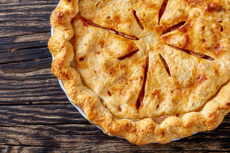 Freshly baked delicious classic homemade American apple pie on an old rustic table, view from above, flatlay, close-upの写真素材