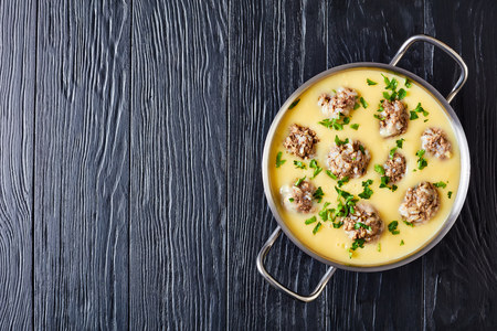 - Giouvarlakia, Youvarlakia in Egg lemon sauce in a metal casserole on a black wooden table, view from above, flatlay, copy spaceの写真素材