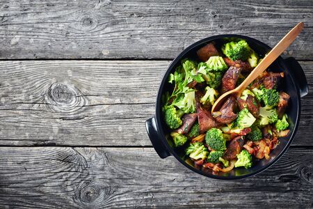 Liver with Broccoli in a black ceramic pan on a grey rustic table, view from above, flat lay, copy spaceの写真素材