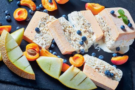 Close-up of melting Sicilian Almond Semifreddo with apricot and melon slicedの写真素材