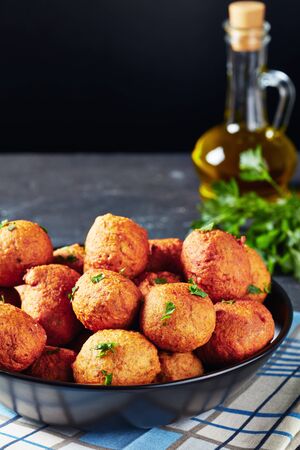 close-up of deep fried Plantain croquettes Klako in a black bowl with ingredients at the black background, african cuisine, vertical viewの写真素材