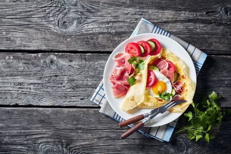 Crepes with fried egg on an old wooden tableの写真素材