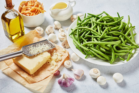 fresh green bean in pods on a white plate on a concrete table with crispy french fried onion rings...