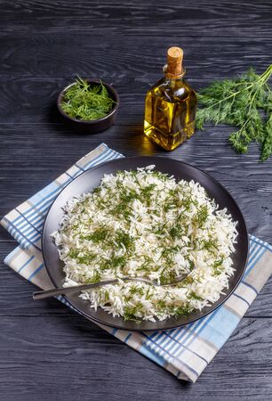 classic Shivid Polow, Persian Dill Rice, traditional Persian side dish served on a black platter on a wooden table, vertical view の写真素材