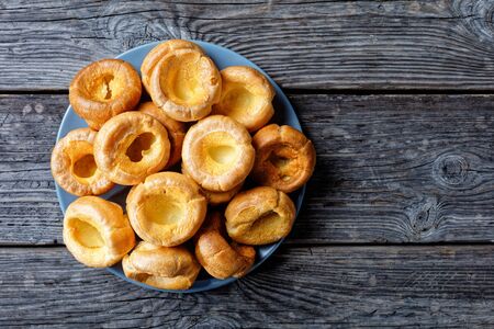 close-up of homemade Yorkshire puddings on a platter on a rustic wooden table, english cuisine, view from above, flatlay, free spaceの写真素材