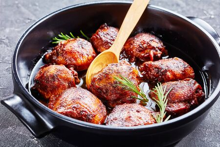 close-up of tender and juicy Brown Sugar Mustard Chicken thighs in a baking dish on a concrete table, horizontal view from aboveの写真素材