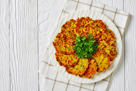 Easy low sodium onion fritters with green herbs and rice, served on a white plate with parsley and...