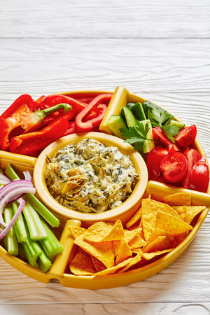 Spinach Artichoke cheese Dip set with Tortilla Chips, cucumber, celery sticks, tomato slices and red...
