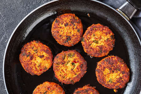 fried thai fish cakes in a skillet on a concrete table, horizontal view from above, close-up, flat lay, free spaceの写真素材