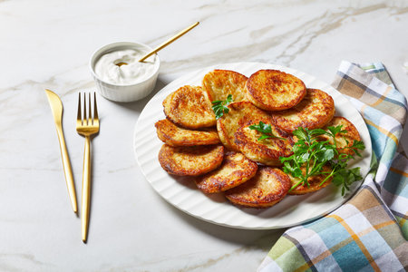 Gluten-free potato pancakes with cottage cheese with garlic, parsley, served with sour cream dip on...