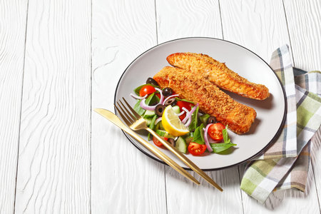 baked salmon fillets breaded with Japanese panko crumbs served with vegetable salad and lemon wedge...