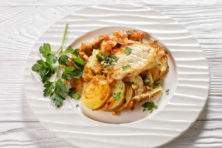 Tartiflette, French Potato, Bacon, and Cheese Casserole on a white plate, close-up, french cuisineの写真素材