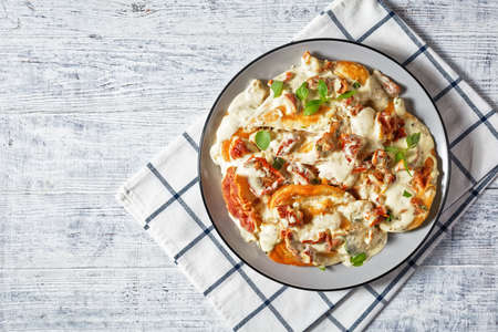 Marry Me Chicken, chicken breasts sauteed in cream sauce with sundried tomatoes, thyme, red pepper flakes, basil and crispy fried bacon served on a plate, flat lay, american cuisineの写真素材
