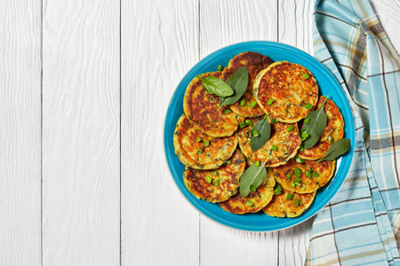 chickpea spinach pancakes on a blue plate on a white wooden table