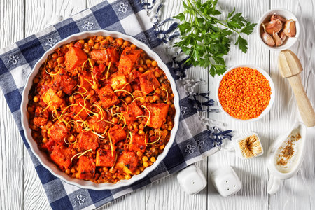 Roasted Pumpkin lentil chickpea dal in a bowl on a white wooden table with ingredients, horizontal view from above, indian cuisine, flat layの写真素材