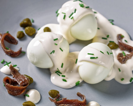 Oeuf mayonnaise, hard boiled eggs covered with a sauce consisting of mayonnaise garnished with...