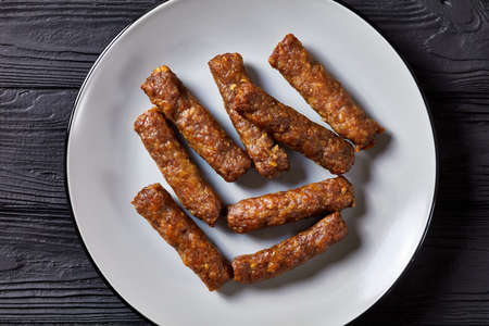 cevapcici, grilled balkan sausages on a plate on a black wooden table, flat lay, close-upの写真素材