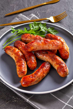 grilled lamb sausages, bangers on a plate on a concrete table, vertical view from above, close-upの写真素材