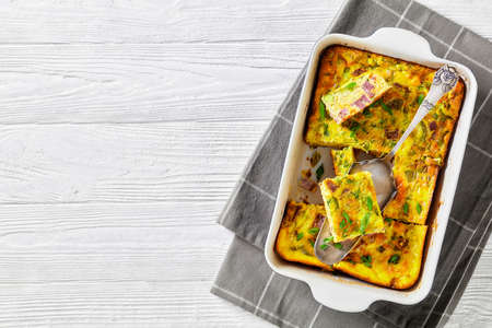 Oven Baked Denver Omelette in a ceramic baking dish on a white wooden table , american recipe,  horizontal view from above, flat lay, free spaceの写真素材