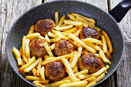 Vitoulet, Gehaktballetjes, Belgian meatballs of ground pork and veal in a skillet with french fries...