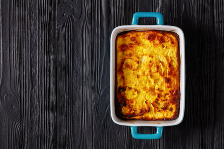 Cottage Cheese casserole in a baking dish on a dark wooden table, flat lay, free spaceの写真素材