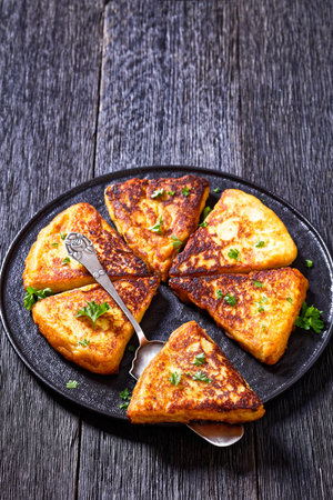 Potato Farls, Irish Potato Cakes, potato bread on black plate on dark wooden table, vertical view...