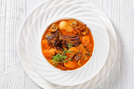 Beef Bourguignon, Beef Burgundy, stew with beef, bacon, carrots, onions and mushrooms slow cooked in rich red wine sauce in white bowl, french cuisine, horizontal view, flat lay, close-upの写真素材