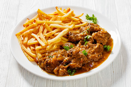Flemish Stew, stoofvlees, carbonnade, beef or pork, beer and onion stew with french fries on white...
