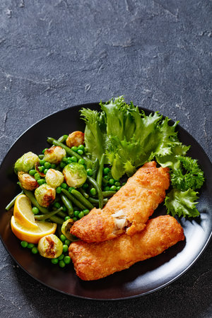 Crispy Beer Batter Cod Fish fillet with roast brussel sprouts, green beans, green peas and fresh...