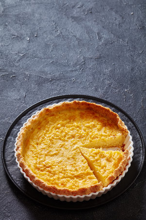 chess pie pairs a traditional butter pie crust with a sweet, custardy filling in white baking dish on concrete table, american cuisine, vertical view, free spaceの写真素材