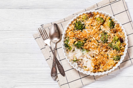 Chicken, Broccoli and mushrooms creamy Casserole topped with panko breadcrumbs in baking dish on white wooden table, horizontal view from above, flat lay, free spaceの写真素材
