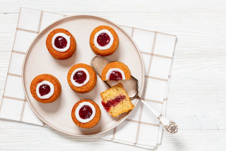 runebergin torttu, runeberg cakes, a finnish mini cakes flavored with almond, raspberry jam and rum on plate on white wooden table, horizontal view, flat lay, free spaceの写真素材